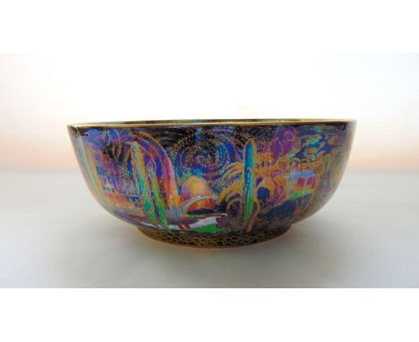 A Wedgewood Fairyland Lustre fruit bowl designed by Daisy Makeig-Jones in the Woodland Bridge pattern against a dark ground t