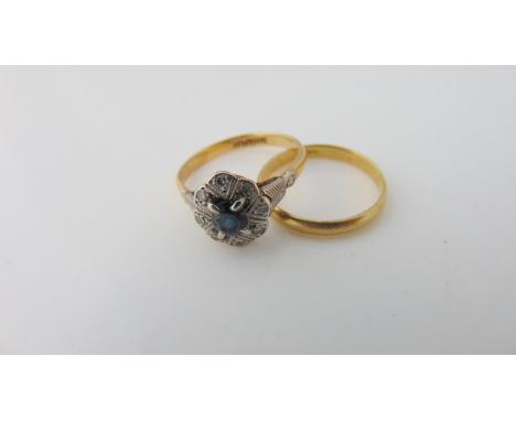 A sapphire and diamond ring, the central untested oval mixed-cut sapphire highlighted with eight single-cut diamonds, in 18ct