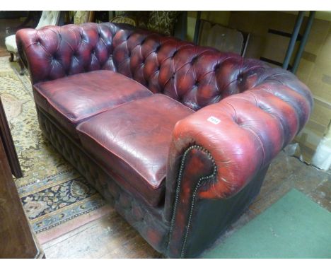 A Victorian style Chesterfield sofa with maroon coloured leather finish and with buttoned panels