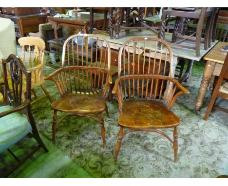 A pair of 18th century style Windsor comb back elbow chairs, principally in ashwood, on turned supports with crinoline stretc