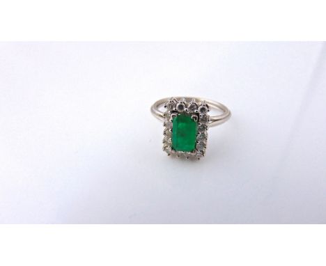 An emerald and diamond ring, centred with a rectangular stepped-cut untested emerald weighing approximately 0.63cts, within a