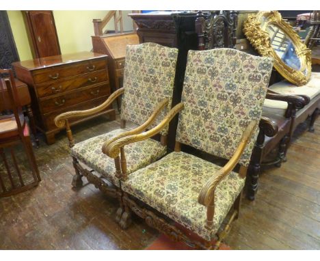 A pair of continental beechwood elbow chairs with acanthus carved and other detail raised on lions paw feet with machine made