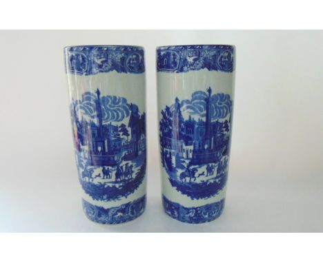 A pair of blue and white ceramic umbrella stands decorated with European street scenes