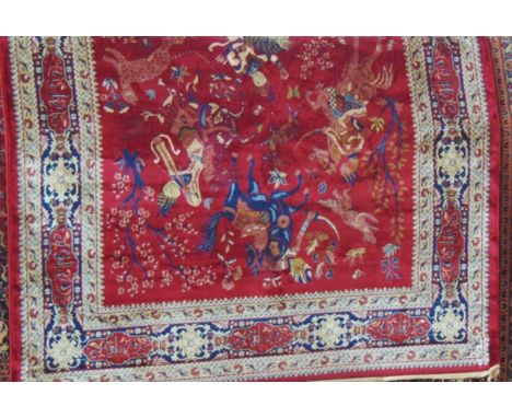 A Persian style red ground wool carpet with hunting scene detail within alternating borders, 310 x 200 cm approx