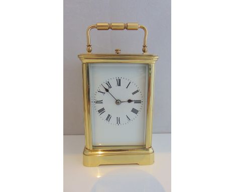 A brass cased carriage clock with enamelled dial, the eight day movement with strike and repeat action