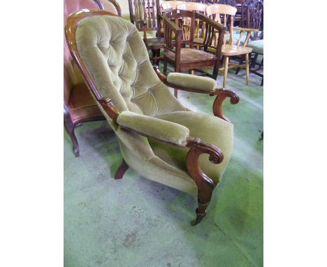 A Victorian rosewood framed drawing room chair with scrolled arms, green velvet upholstery with button back raised on turned 