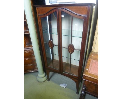 An Edwardian mahogany display cabinet enclosed by two threequarter length glazed panelled doors with marquetry detail, with w