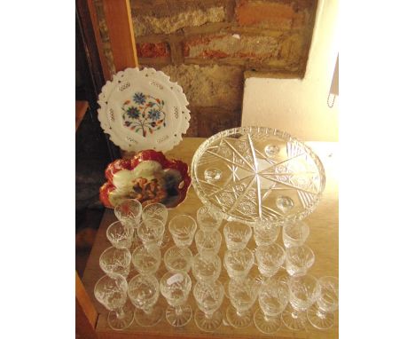 A selection of 25 clear cut liqueur glasses, some matching, together with a heavy clear cut glass stand of circular form rais