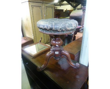 A Victorian rosewood piano stool with rising seat and buttoned green leather, raised on a turned pillar and tripod base