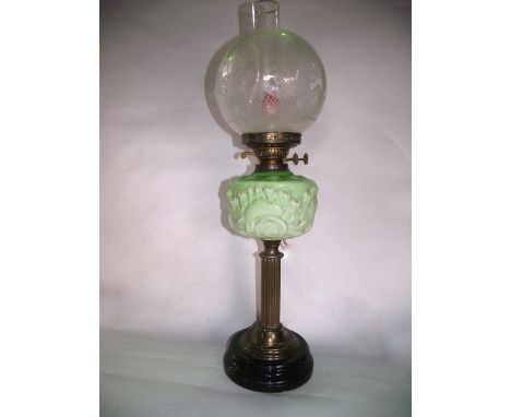 A Victorian oil burning lamp with fluted column stand leading to an opaque vaseline coloured font beneath a duplex burner wit