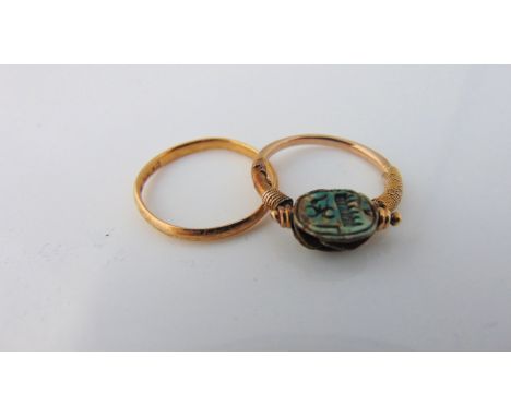 A scarab beetle ring, the unmarked gilt band set with a swivel scarab motif, size H; and a 22ct gold wedding band, 1.4g, size