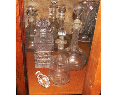 A selection of glass decanters to include a heavy example of square form with printies and other cut detail, a mallet shaped 