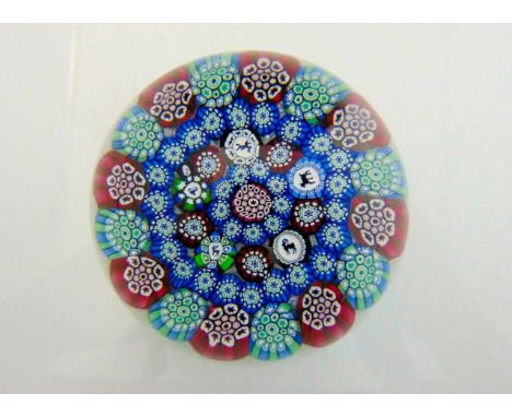 A Scottish millefiori glass paperweight by John Deacons, the white latticino cane field accommodating a bed of stars and cane