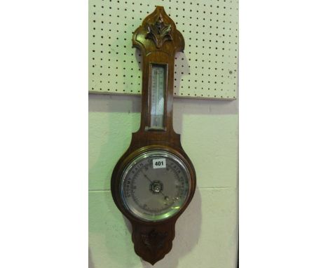 An Edwardian walnut aneroid barometer with carved detail and silvered dials