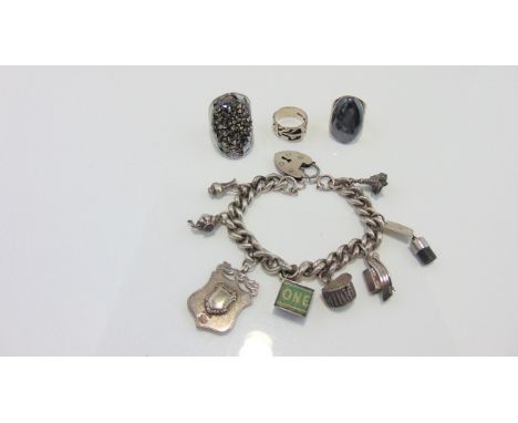 A white metal charm bracelet, the curb-links suspended with eight silver and white metal charms, with silver heart-shaped pad