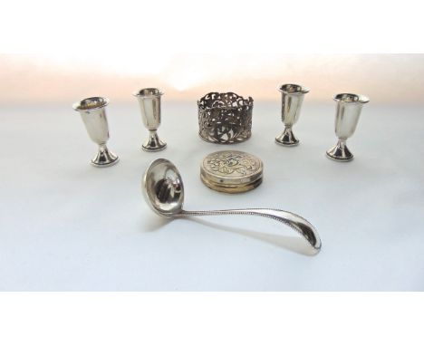 A set of four sterling silver liquor cups, each with gilt interior, 97.8g; a Dutch silver sauce ladle, 1915, with bead patter