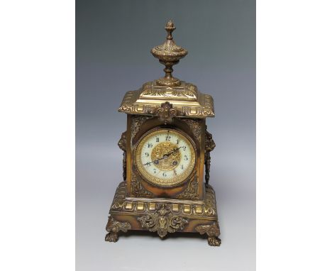 A 19TH CENTURY BRASS MANTEL CLOCK, the enamel face with inner pierced gilt mask head detail, the movement stamped '10800' and