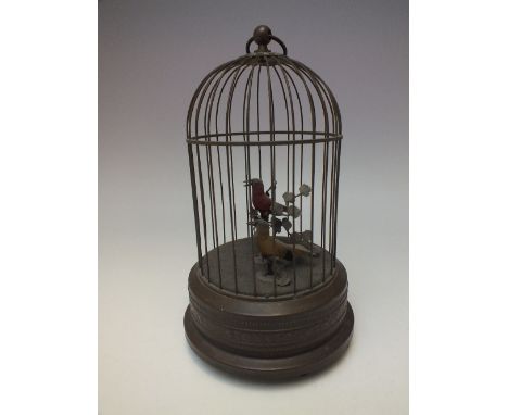 A 20TH CENTURY AUTOMATON MUSICAL BIRD CAGE, with two birds seated on branches, of circular form, raised on three feet, H 28 c
