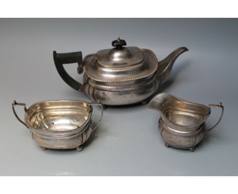 A HALLMARKED SILVER THREE PIECE TEA SERVICE BY C S HARRIS &amp; SONS LTD - LONDON 1931, sitting upon four bun feet and having