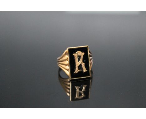 A 9 CARAT GOLD GENTS RING, having black onyx inlaid with a gold letter 'R' in a rectangular panel, H 1.75 cm, ring size U