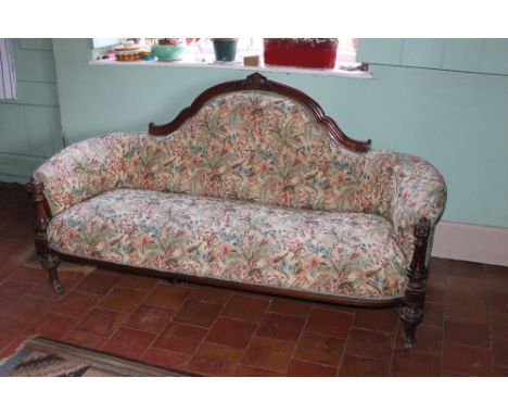 A 19TH CENTURY MAHOGANY FRAMED SHAPED SETTEE, with carved detail to the top rail, raised on turned carved supports, castors, 