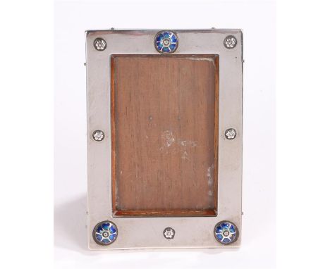 Liberty & Co Ltd silver picture frame, Birmingham 1915, with blue enamel stylised flower head roundel decoration,wooden easel