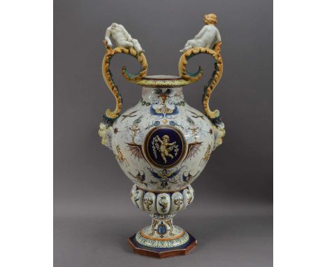 A large and damaged early 20th century Italian Maiolica large urn, twin handled, both handles with cherubs (one with a broken