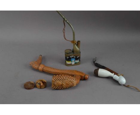 Three opium pipes, one wooden, one metal with enamel decoration, 27cm high and another, together with a miniature wooden tea 