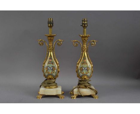 A pair of decorative 20th century lamps, brass with enamel panels, on shaped onyx bases, with paw feet, both 44cm high, will 