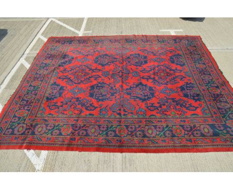 A large Donegal Irish carpet, restored, formally cut for furniture, red, green and blue geometric design, 390cm x 320cm