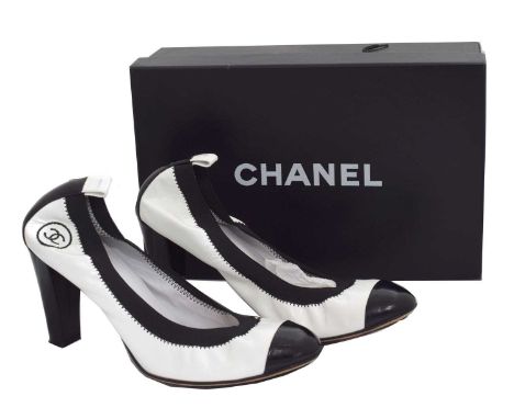 A pair of Chanel 'Spirit Stretch' heels. Each designed as a patent white leather heel with black patent leather cap toe and m
