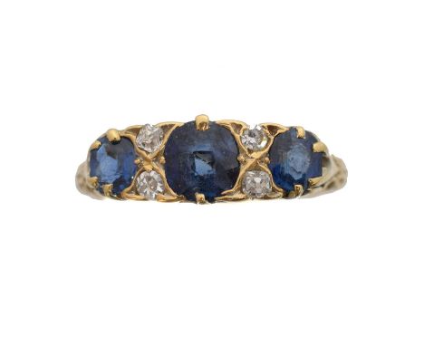 A late Victorian 18ct gold sapphire and diamond dress ring. The cushion shape sapphire line with old cut diamond duo spacers,