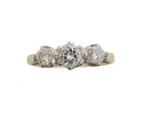 An 18ct gold diamond three stone ring. The brilliant cut diamond line within shared claw settings, estimated total diamond we