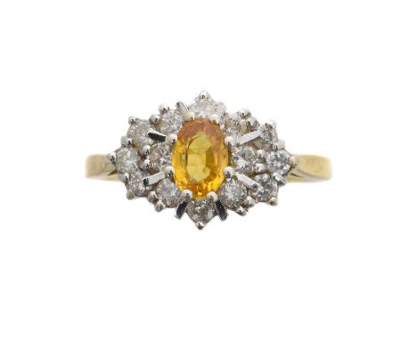 An 18ct gold sapphire and diamond cluster ring. The oval shape yellow sapphire within a brilliant cut diamond surround, total