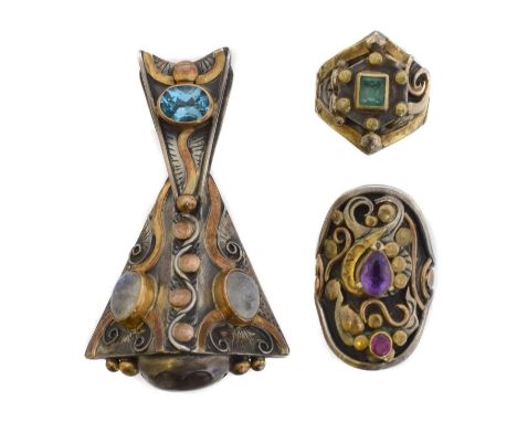 A selection of gem-set jewellery. Including a blue topaz, moonstone and rutilated quartz pendant, an emerald shield ring, and