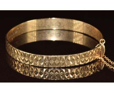 A 9ct gold bangle with cut out decoration, 14.2g, 5.8 x 5.2cm
