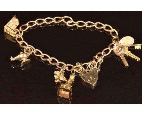 A 9ct gold charm bracelet made up of twisted oval links with five charms including three keys and 'if found return to', Eiffe