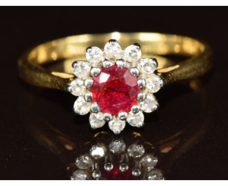 A yellow metal ring set with a round cut ruby of approximately 0.4ct surrounded by diamonds, 3.5g, size P