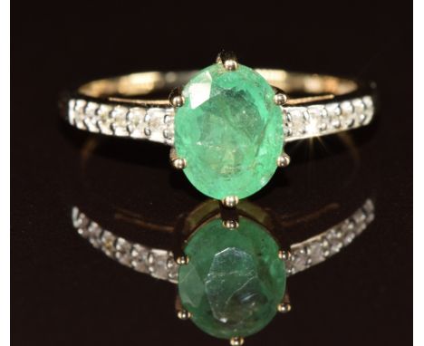A 9ct gold ring set with an oval cut emerald and diamonds to the shoulders, 2.2g, size R/S