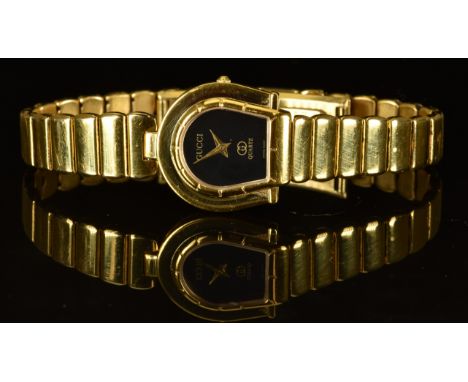 Gucci ladies wristwatch ref. 7000 with gold hands, black dial, gold plated horseshoe shaped case and quartz movement, on gold