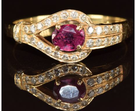 An 18ct gold ring set with an oval cut ruby and diamonds, 3.3g, size R