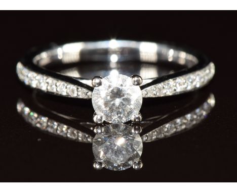 An 18ct white gold ring set with a 0.42ct round brilliant cut diamond and further diamonds to the shoulders, with original Be