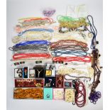 A collection of costume jewellery including beaded necklaces, pearl earrings, pheasant brooch,