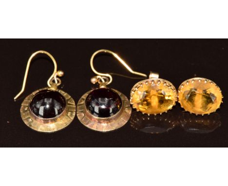 A pair of Victorian earrings each set with a garnet cabochon and a pair of earrings each set with an oval cut citrine, 6g