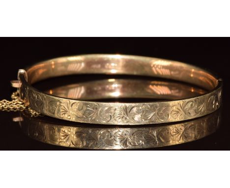 A 9ct gold bangle with engraved scrolling decoration, 9.1g, 5.3 x 6cm
