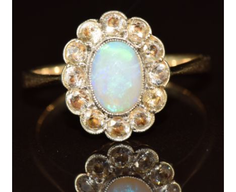 A 9ct gold ring set with an opal cabochon surrounded by zircons, 2.2g, size L