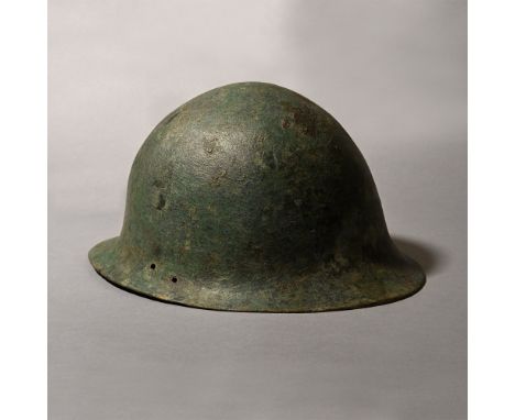 8th century B.C. With rounded bowl and flared rim; three sets of paired piercings for attachment of leather cheek-flaps; crac