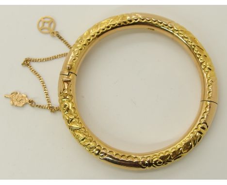 An 18ct gold dragon embossed bangle stamped 750 to the inside, inner diameter 5.2cm, thickness of bangle approx 6.7mm, weight