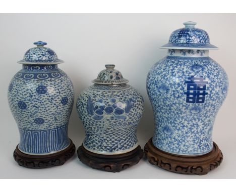 A Chinese blue and white tea jar painted with Shou characters and scrolling foliage, beneath a key pattern collar, wood stand