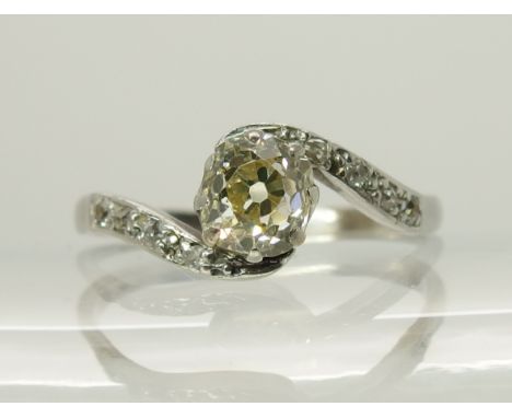 A platinum old cushion cut diamond ring of estimated approx 0.80cts with further diamonds to the scrolling shoulders, finger 